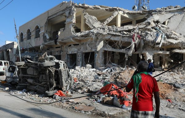 Local residents look at debris from a destroyed building in Mogadishu on October 30 after a car bombing targeted the education ministry the day before, killing at least 100. [Hassan Ali Elmi/AFP]