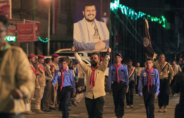 Yemeni youths march with a portrait of Houthi leader Abdul-Malik al-Houthi on September 20, during a parade commemorating the eighth anniversary of the Iran-backed group's coup in Sanaa. [Mohammed Huwais/AFP]