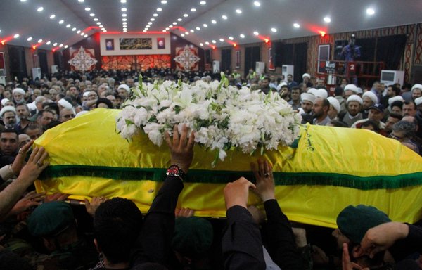 Members and supporters of Lebanese Hizbullah carry the coffin of Mustafa Badreddine, a top Hizbullah commander who was killed in an attack in Syria, at the martyrs' cemetery in the Ghobeiry neighbourhood of southern Beirut on May 13, 2016. [Stringer/AFP]