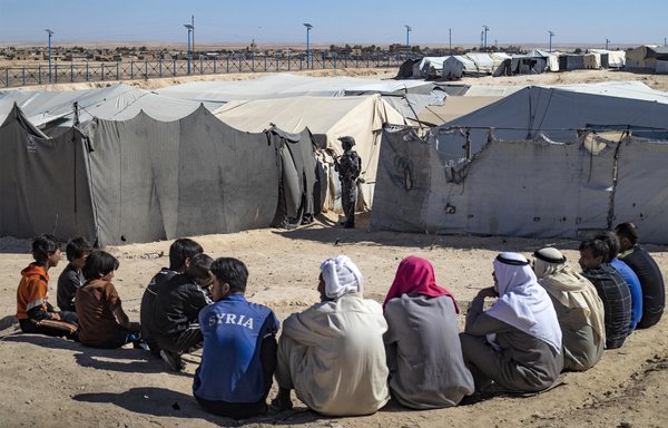 A member of the Asayesh (Kurdish internal security forces) stands guard during an inspection of tents at al-Hol camp, which holds relatives of suspected ISIS fighters, on August 28. [Delil Souleiman/AFP]