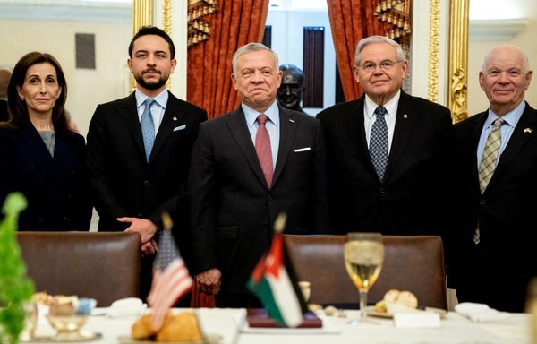 King Abdullah II of Jordan stands for a photo with US Sen. Bob Menendez, chairman of the Senate Foreign Relations Committee, and US Sen. Ben Cardin at the US Capitol in Washington, DC, on May 10. [Stefani Reynolds/AFP]