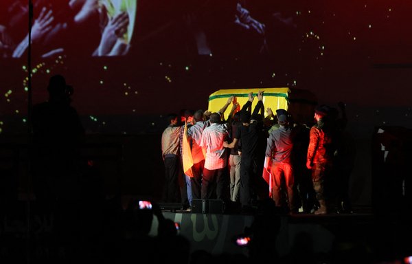 Hizbullah supporters hold up a mock coffin depicting late commander Imad Mughniyeh during a celebration marking the 40th anniversary of the party's creation in the southern suburb of Beirut on August 22. [Anwar Amro/AFP]
