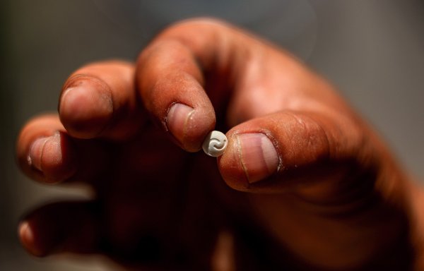 A Lebanese security official holds a single confiscated Captagon pill in his hand at the judicial police headquarters in the city of Zahle in Lebanon's Bekaa Valley on July 21. [Joseph Eid/AFP]
