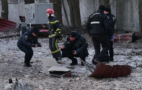 Rescuers and police experts examine remains of a drone following a strike on an administrative building in the Ukrainian capital Kyiv on December 14. President Volodymyr Zelenskyy said Ukrainian air defence systems had shot down 13 Iranian-made kamikaze drones that targeted Kyiv earlier in the day. [Sergei Supinsky/AFP]