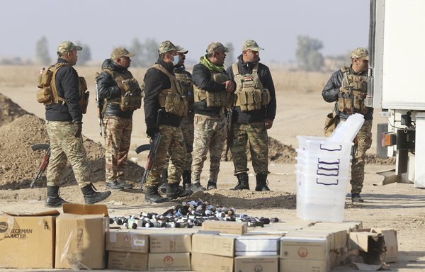Iraqi soldiers stand guard as government officials prepare to destroy nearly six tonnes of drugs in Baghdad's Nahrawan area on December 18. [Sabah Arar/AFP]