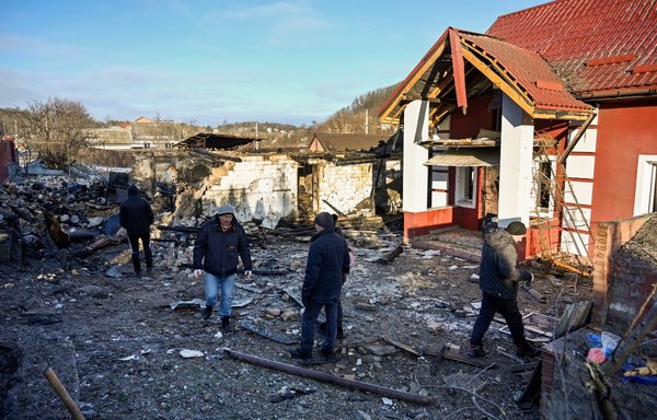 Local residents inspect the debris following a barrage of drone strikes from Russia in Stari Bezradychi village, Kyiv province, Ukraine, on December 19. [Sergei Chuzavkov/AFP]
