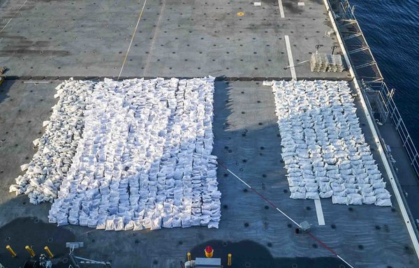 Bags containing more than 50 tonnes of fuses and propellants for rockets and ammunition rounds sit on the flight deck of the expeditionary mobile base vessel USS Lewis B. Puller on December 3. Forces from the Lewis B. Puller seized the cache from a fishing trawler in the Gulf of Oman along a maritime route from Iran to Yemen. [US Navy]