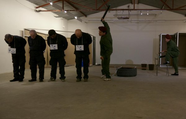 A scene from a play based on the testimony of a former Lebanese detainee in Syrian prisons shows a prison guard beating an inmate. [UMAM Documentation & Research]