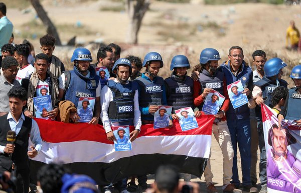 Journalists and mourners lift placards and banners in Taez during the funeral of TV reporter Adib al-Janani, who was killed in a Houthi attack on Aden airport on January 2, 2021. [Ahmad al-Basha/AFP]