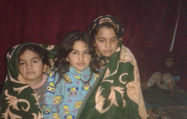 أطفال لاجئون سوريون في مخيم ببلدة إيعات شرقي بعلبك. وتعيش ولاء فواز المنصور (في الوسط) التي تعاني من نوبات صرع مزمنة، مع والديها وإخوتها دون وسائل تدفئة في خيمة سقفها وجوانبها ممزقة. [محمد زكور الحج]