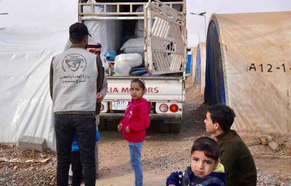 An employee of the Iraqi Ministry of Migration and Displacement helps a family at al-Jadaa camp, south of Mosul, return to their hometown on December 21, 2021. [Iraqi Ministry of Migration and Displacement]