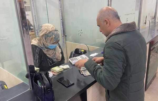 An Iraqi buys dollars from a branch of the government-run al-Rafidain Bank on December 25. [Al-Rafidain Bank]