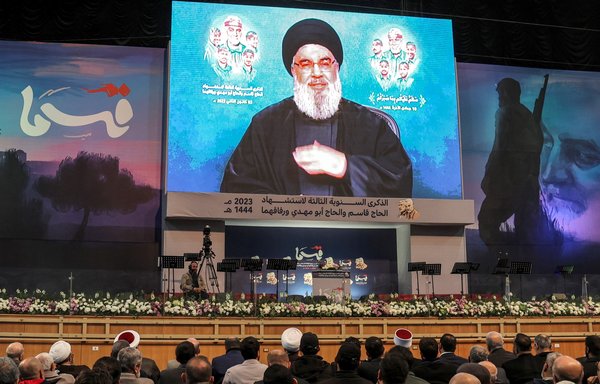 Supporters of Hizbullah attend a televised speech by the group's leader, Hassan Nasrallah, in Beirut's southern suburbs on January 3. The United States sanctioned economist Hassan Moukalled on January 24 for helping himself and Hizbullah to profit from Lebanon's economic crisis. [Anwar Amro/AFP]
