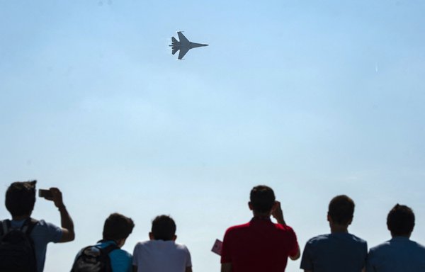 Spectators look on as a Russian Su-35 fighter flies during an air show in Istanbul on September 17, 2019. [Yasin Akgul/AFP]