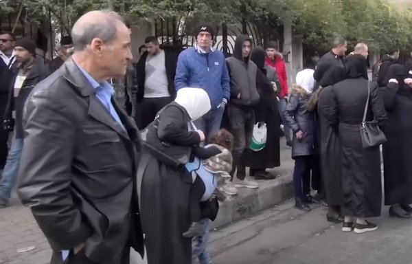 Syrian citizens wait for hours for public buses, most of which have stopped operating from the scarcity and high prices of fuel, in this video grab, posted December 13. [Ninar FM]