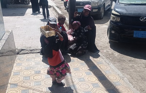 A child holds an empty basket to request food or monetary donations on the street outside a restaurant in Sanaa. [Haitham Mohamed/Al-Mashareq]