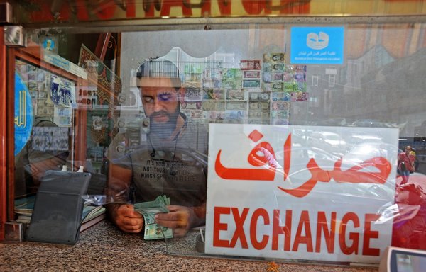 A money changer counts notes at his shop in the Lebanese capital Beirut on September 22. [Anwar Amro/AFP]