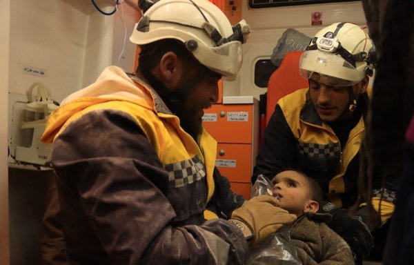 Two members of the White Helmets tend to a child recovered from under the rubble in rural Idlib on February 7. [White Helmets]
