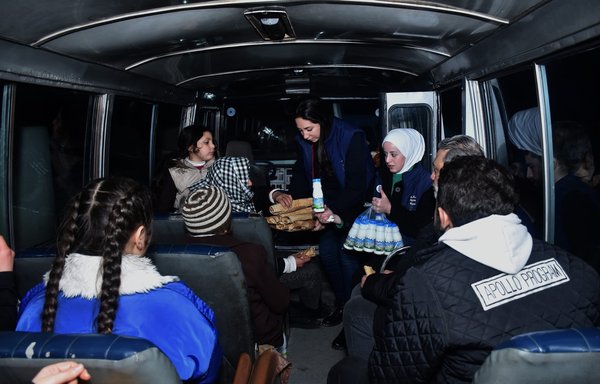 Two volunteers distribute food among earthquake survivors in Syria on February 7. [Syria Trust for Development]