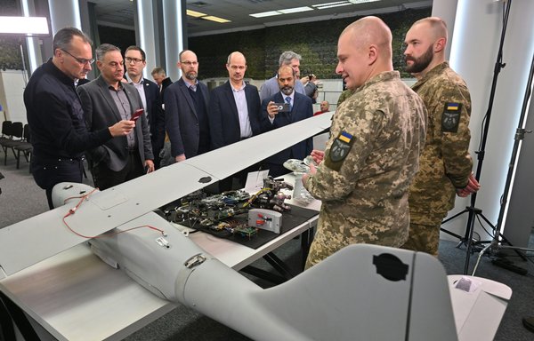 Representatives of diplomatic missions in Ukraine examine downed drones Russia allegedly uses for striking critical Ukrainian infrastructure and other targets, in Kyiv on December 15. [Sergei Supinsky/AFP]