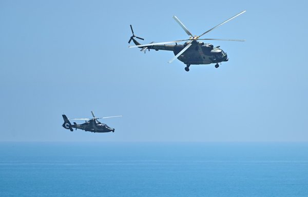 Chinese military helicopters fly past Pingtan island, one of mainland China's points closest to Taiwan, in Fujian province on August 4, ahead of massive military drills off Taiwan, in a show of force straddling vital international shipping lanes. [Hector Retamal/AFP]