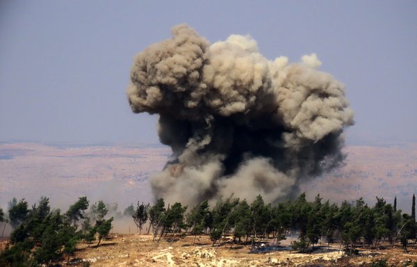 Smoke billows at the site of a reported Russian strike in a forest area west of Syria's northwestern city of Idlib, on August 22. [Muhammad Haj Kadour/AFP]