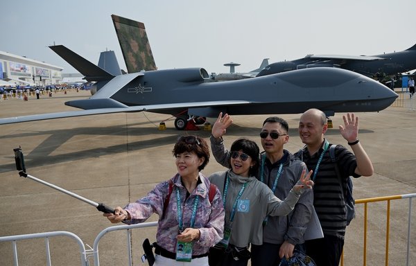 Visitors take photos in front of a Chinese air force WZ-7 drone at the 13th China International Aviation and Aerospace Exhibition in Zhuhai, China, September 28, 2021. China is negotiating to supply Russia with drones, Der Spiegel reported this week. [Noel Celis/AFP]