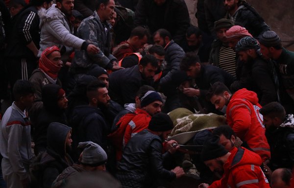 Syrian civilians and Syrian Arab Red Crescent personnel rescue someone trapped under the rubble following the devastating earthquake of February 6. [Syrian Arab Red Crescent]