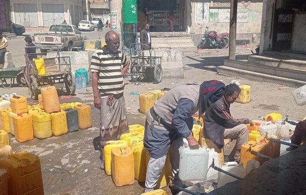 ساکنان صنعا برای تهیۀ آب از چاه یک مسجد در صف ایستاده‌اند. بعضی از ساکنان در ازای دستمزد ناچیز کار حمل آب انجام می‌دهند. [هیثم محمد/المشارق]