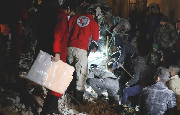 Volunteers and civilians in Latakia try to reach survivors using primitive tools on February 8, following a devastating earthquake. The Russians have a heavy presence in Latakia. [Syrian Arab Red Crescent]