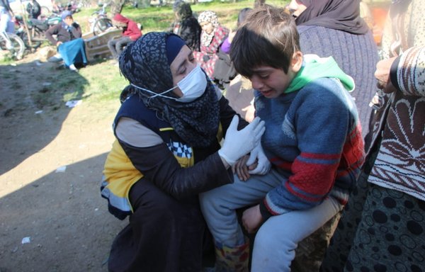 A member of the White Helmets consoles a Syrian child who lost his friends in the earthquake, on February 10. [White Helmets]
