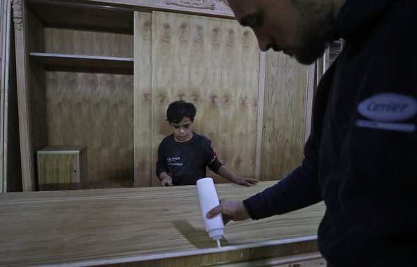 حیدر کرار، کودک ۱۳ سالهٔ عراقی، که از ۸ سالگی در مغازهٔ نجاری عموی خود کار می‌کند، در روز ۱۱ بهمن مشغول نظافت این کارگاه است. [احمد الربیعی/ خبرگزاری فرانسه]