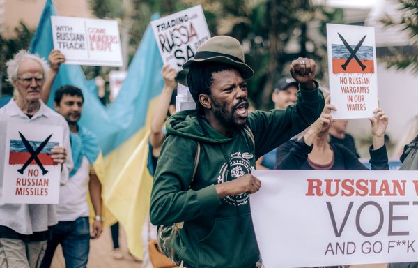 متظاهرون من الرابطة الأوكرانية بجنوب إفريقيا وناشطون من المجتمع المدني يشاركون في تظاهرة على شاطئ أوملانجا في دربان يوم 18 شباط/فبراير، احتجاجا على المناورات العسكرية المشتركة التي أجرتها جنوب إفريقيا مع روسيا والصين على طول ساحلها الشرقي في خليج ريتشاردز. [راجيش جانتيلال/وكالة الصحافة الفرنسية]