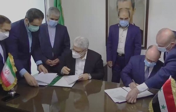 Syrian and Iranian delegations, seen here in a screenshot from a video posted March 4, sign an agreement. [SANA News Agency]