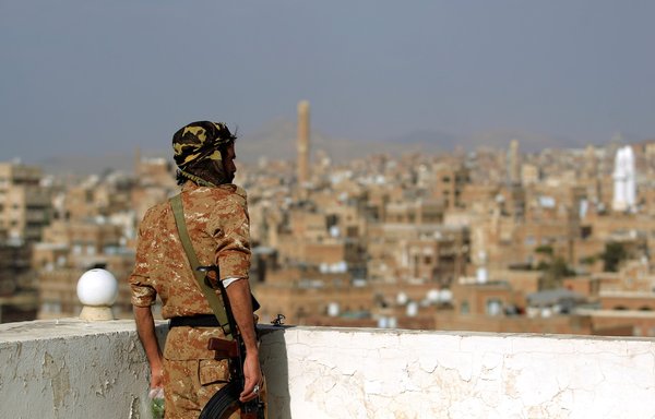 A member of the Houthi-affiliated forces looks out at the old city of Sanaa, which the Iran-backed group seized in a September 2014 coup, on February 24. [Mohammed Huwais/AFP]