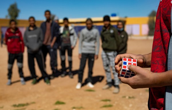 The son of an ISIS foreign fighter holds a Rubik's cube in the playground of the Orkesh rehabilitation centre in Qamishli on March 7. [AFP]
