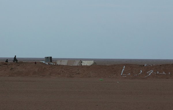 A picture taken November 12, 2018, from al-Qaim in Iraq's Anbar province on the border with Syria shows Syrian regime forces guarding the Albu Kamal crossing in the Syrian eastern province of Deir Ezzor. Pro-regime Iranian forces have established a heavy presence in the area. [Ahmad al-Rubaye/AFP]