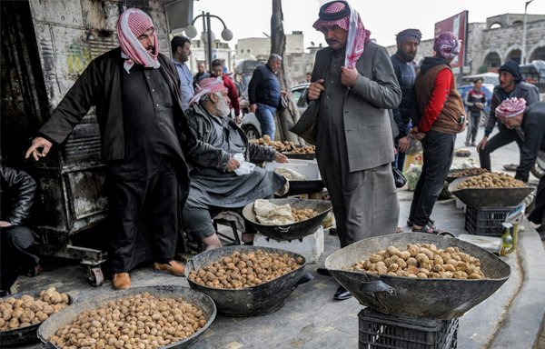 تجار يعرضون الكمأ الصحراوي في أحد أسواق حماة. وقال المرصد السوري لحقوق الإنسان إن أكثر من 150 من صيادي الكمأ قد قتلوا حتى الآن هذا الموسم، معظمهم بسبب هجمات المتطرفين والألغام الأرضية. [لؤي بشارة/وكالة الصحافة الفرنسية]