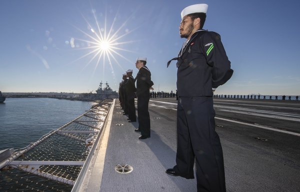 Hundreds of sailors aboard the USS Gerald R. Ford (CVN 78) stand at attention last November following the ship's inaugural deployment. [US Navy]