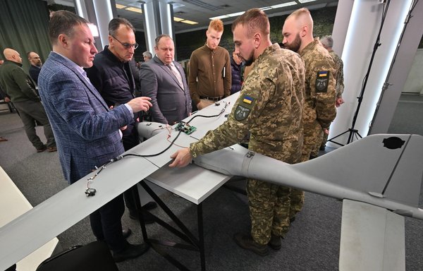 Representatives of diplomatic missions in Ukraine examine downed drones that Russia allegedly uses for striking critical infrastructure and other targets in Ukraine during a news conference in Kyiv on December 15. [Sergei Supinsky/AFP]