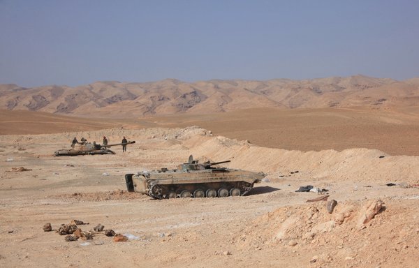 Tanks belonging to Syrian regime forces are positioned near the Jazel oil field, near the ancient city of Palmyra in the east of Homs province in March 2015. Lebanese Hizbullah and other Iranian militias have since established a presence in the area. [AFP]