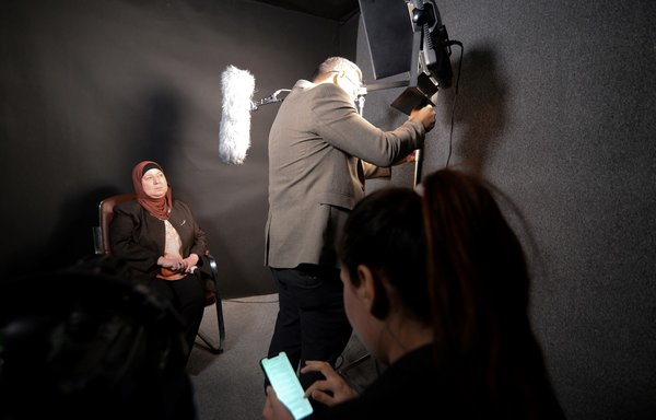 An Iraqi woman prepares to share her memories of what she endured under ISIS, during a filmed interview with members of the Mosul Eye project, in Mosul on February 27. [Zaid al-Obeidi/AFP]