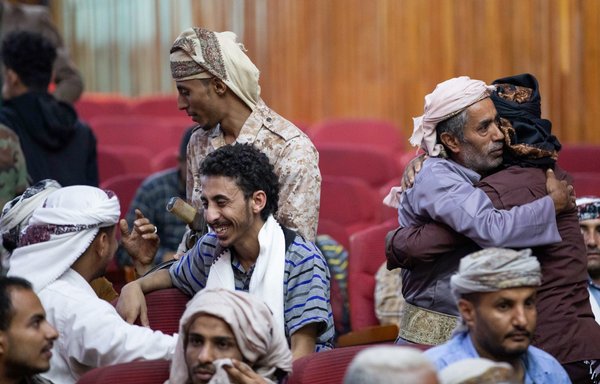 Yemenis greet their freed relatives during a prisoner exchange ceremony between Houthi and government forces in Taez province on September 29, 2021. [Ahmad al-Basha/AFP]