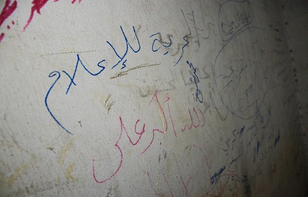 Arabic writings on cell walls, written by prisoners held captive by ISIS, read: 'Freedom for the media', in an ISIS prison in the northern Syrian town of al-Bab in March 2017. [Nazeer al-Khatib/AFP]