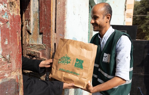 A charitable organisation worker delivers an iftar meal in a rural area of Egypt's Luxor province, as part of the Iftar Saem (Fasting Meal) Campaign. [Misr El Kheir Foundation]