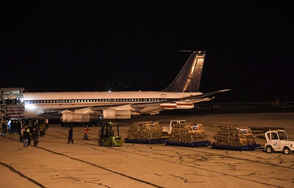 Workers unload aid sent by Iran by plane, at the airport in Syria's northern city of Aleppo early on February 8, following a deadly earthquake. A new Reuters report reveals that weapons have been brought in under the guise of aid. [AFP]