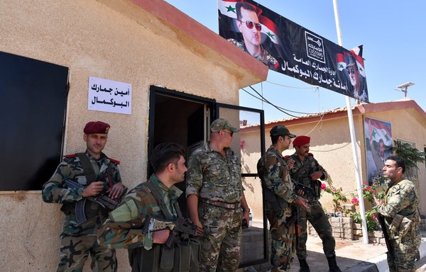 Syrian regime forces gather on the Syrian side of the border crossing between Albu Kamal in Syria and al-Qaim in Iraq on September 30, 2019. Regime ally Iran has a heavy presence in the area and has used informal crossings to facilitate smuggling activity. [AFP]
