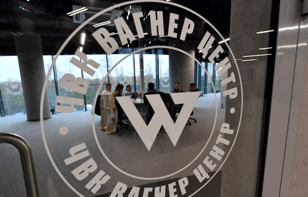 People sit in the office of the 'PMC Wagner Centre', associated with Wagner Group founder Yevgeny Prigozhin, during the official opening of the office block in St. Petersburg, Russia, on November 4. [Olga Maltseva/AFP]