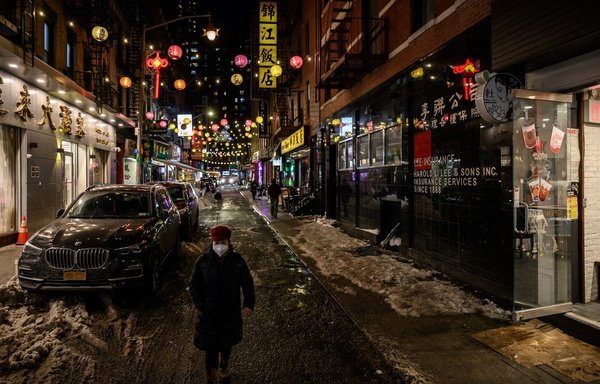 A pedestrian walks along a street in the Chinatown area of New York City on January 31, 2022. [Ed Jones/AFP]
