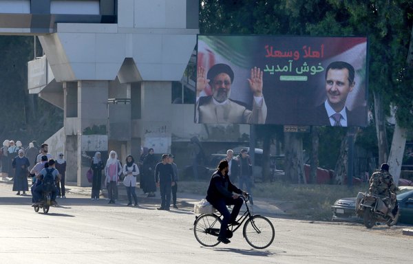 A billboard with pictures of Iranian President Ebrahim Raisi and Syrian President Bashar al-Assad is seen in Damascus on May 3. [Louai Beshara/AFP]